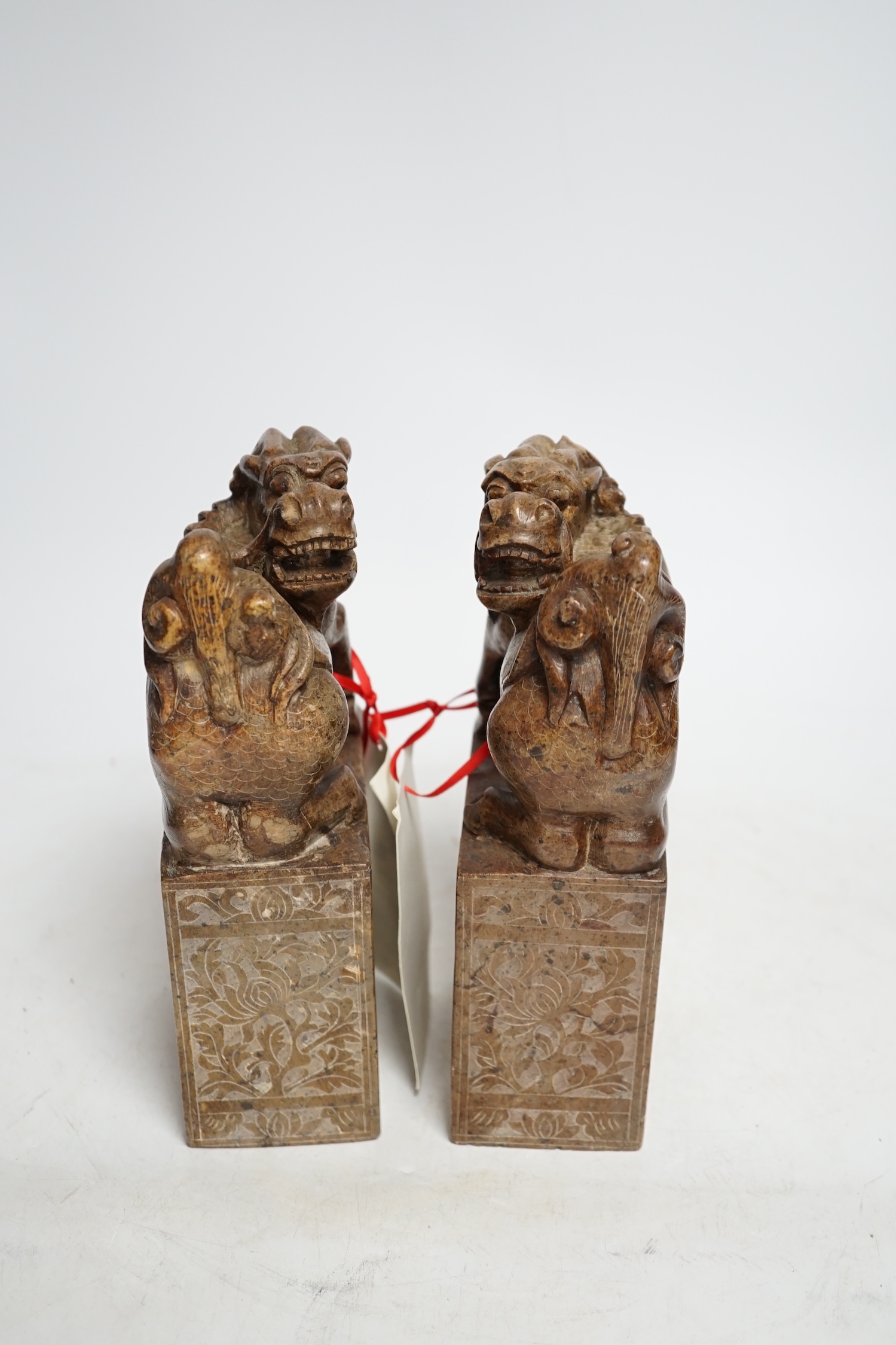 A pair of Chinese soapstone lion-dog and cub seals, 19cm high